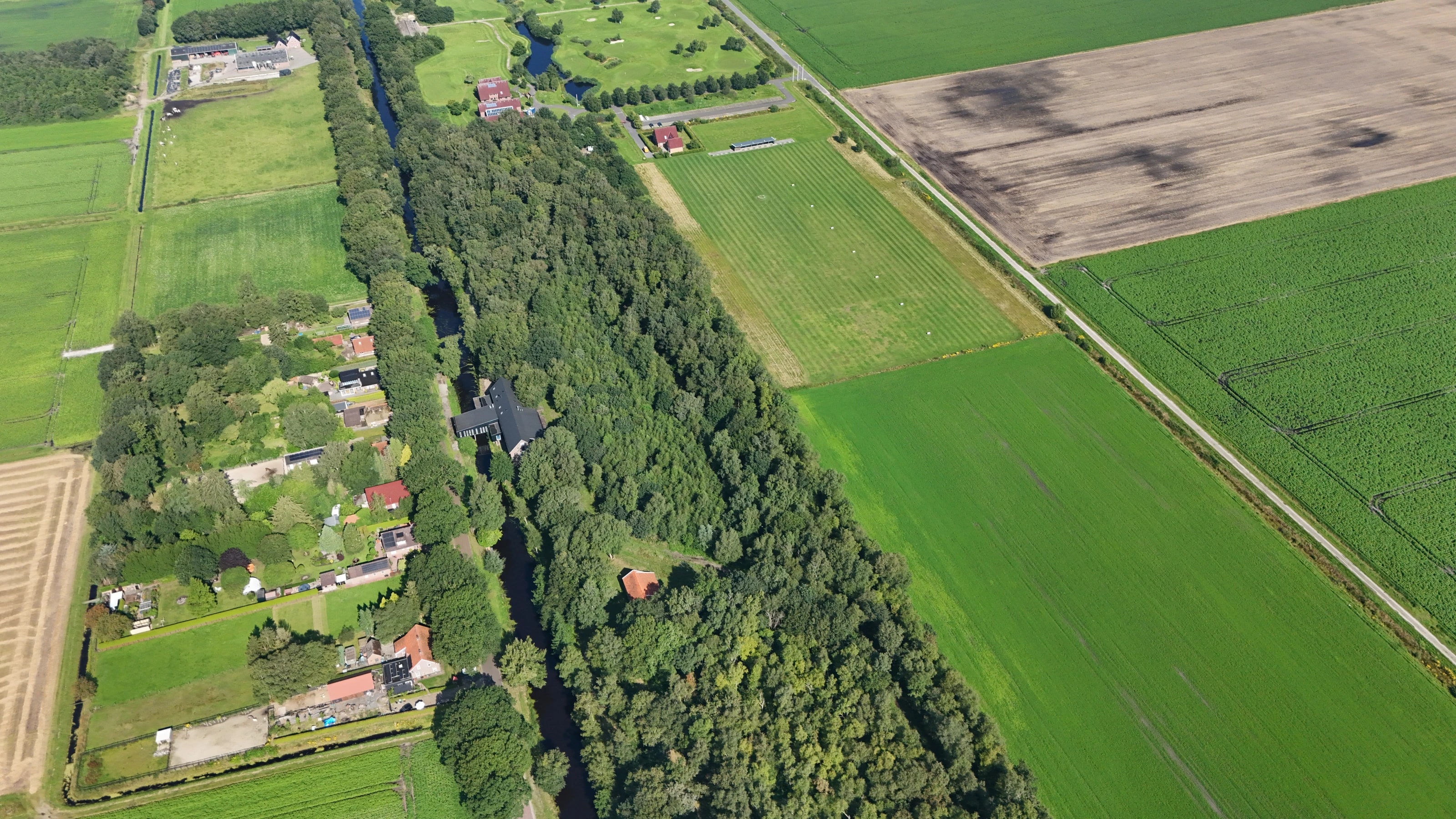 Cozmoss verscholen tussen bomen en velden in het groen van Drenthe, vanuit de lucht