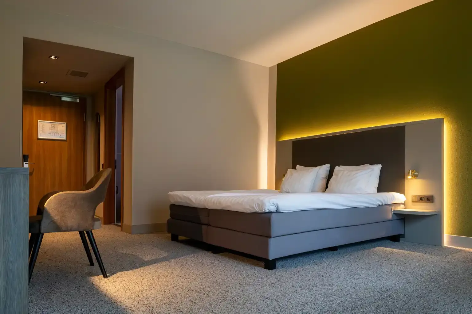 Kamer Mos met kingsize bed en warme wandverlichting